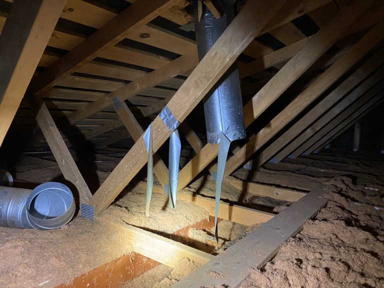 an attic with hanging bits of duct tape