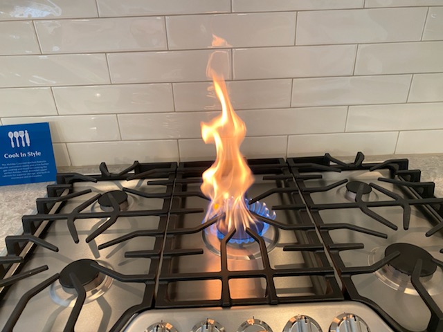 a large flame coming out of a stovetop burner