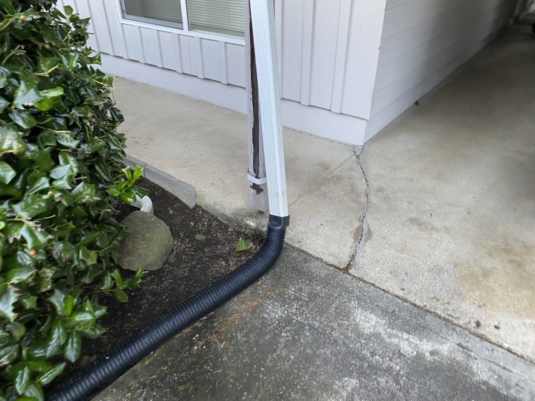 a downspout off of a roof connected to a tube