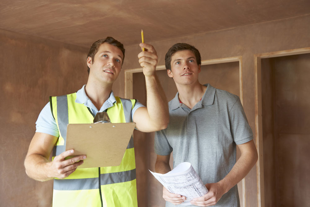 A home inspector with a homeowner pointing at the ceiling