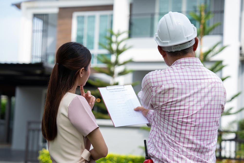 A home inspector speaks with a client about a property.