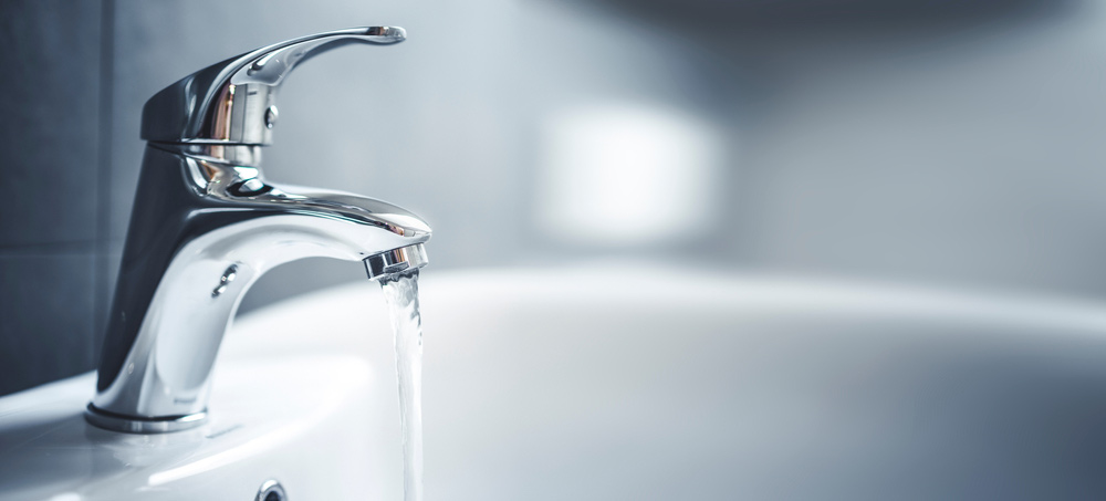 Water runs out of a faucet during a plumbing home inspection.